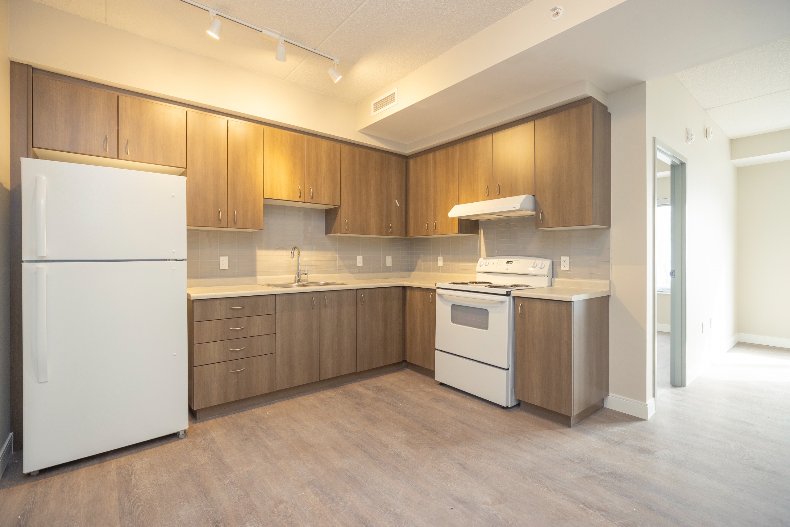 image of a kitchen with stove, countertops and fridge