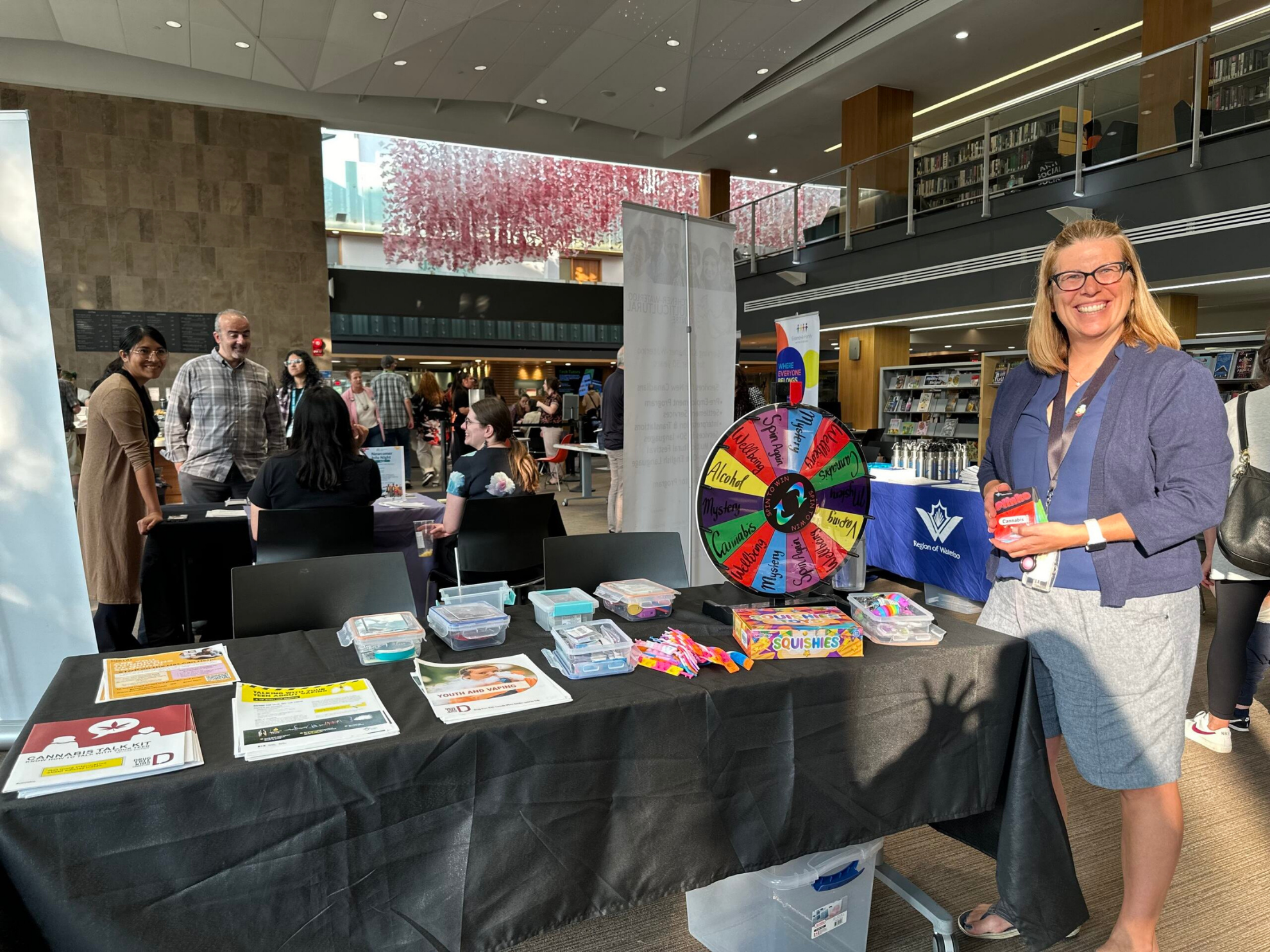 A public health staff member stands at a booth at a preventing substance use among youth event