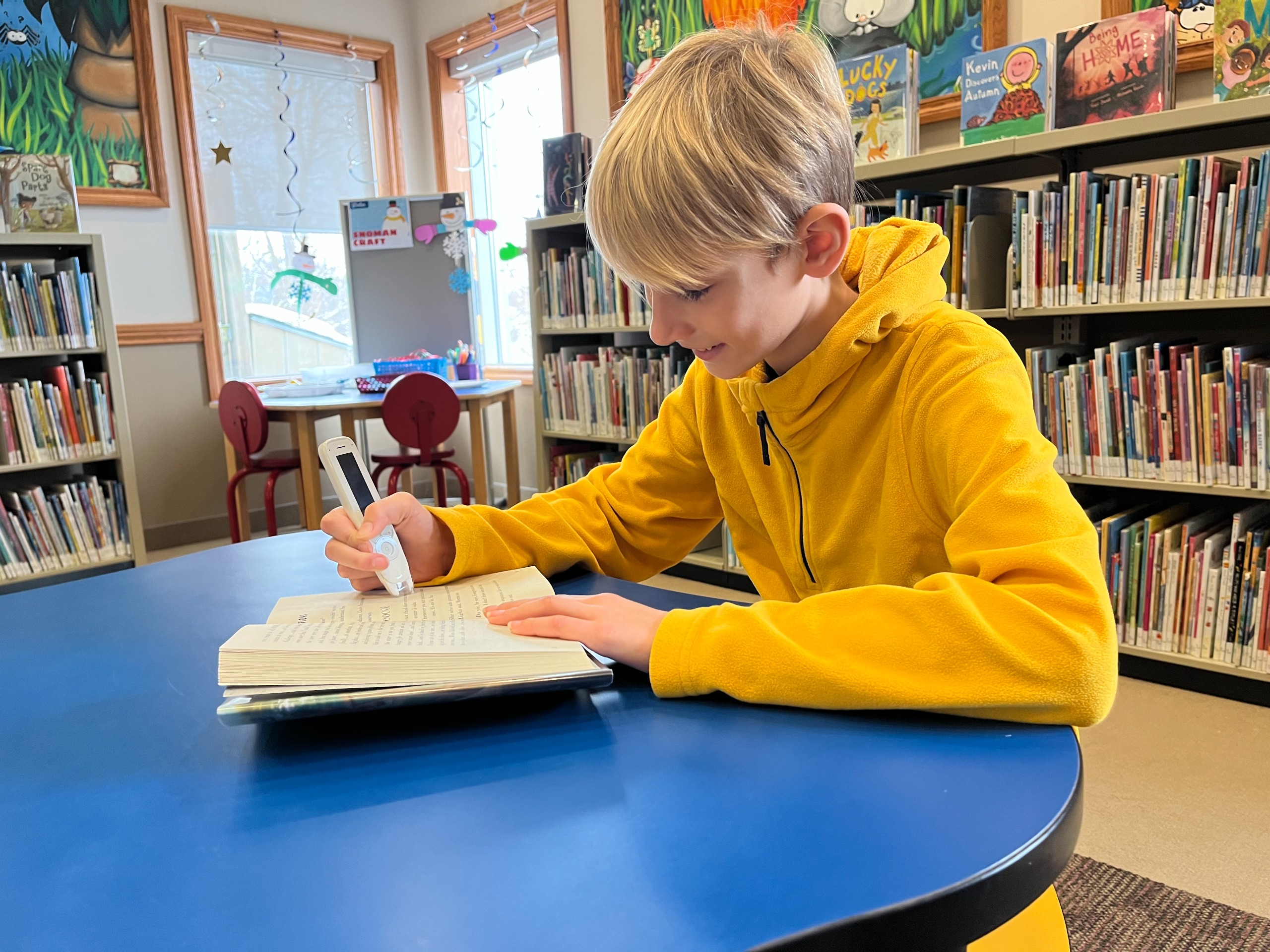 A boy uses a c-pen at the Ayr library