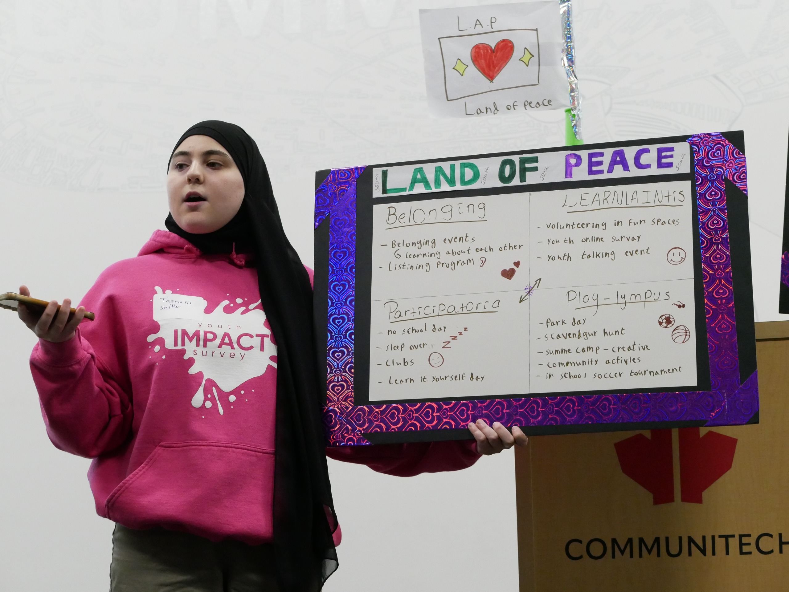 A youth showing her project at the Impact and Action Youth Summit