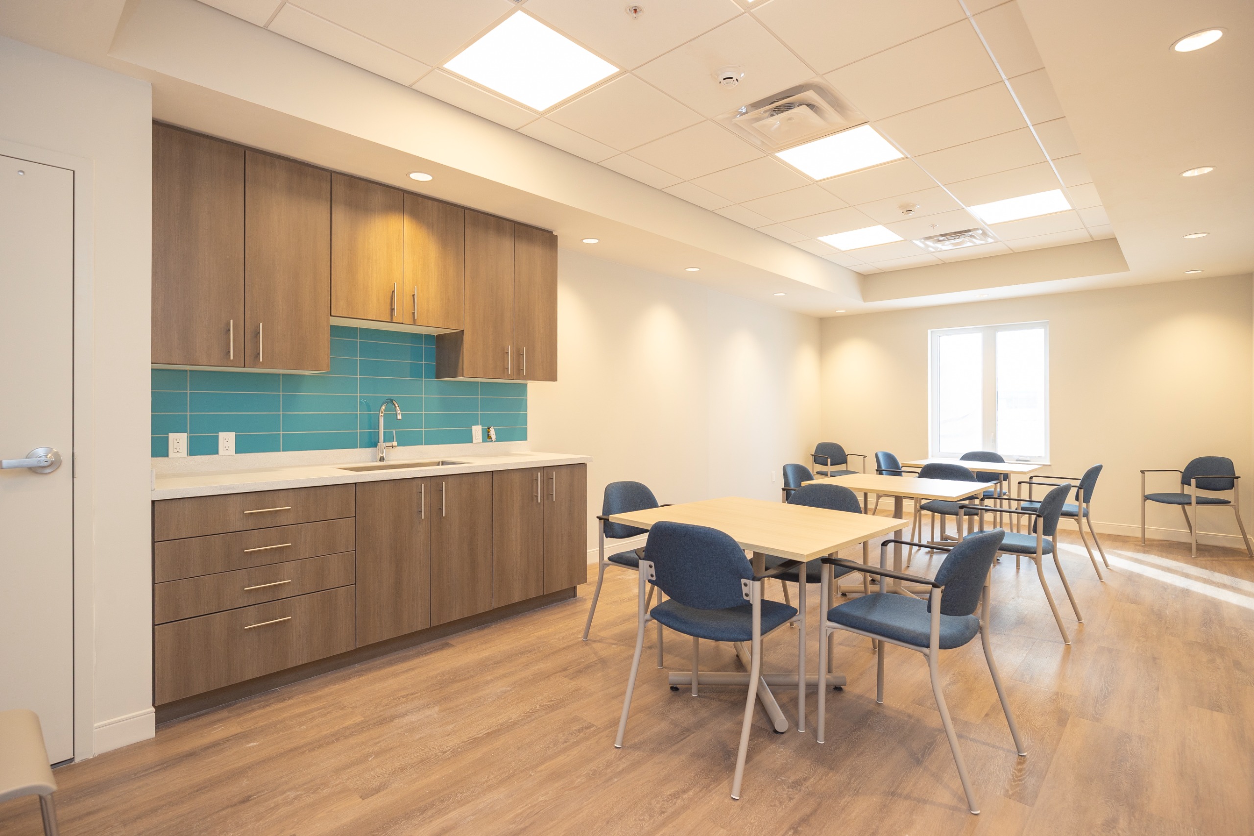 image of an amenity room with kitchen countertops, tables and chairs