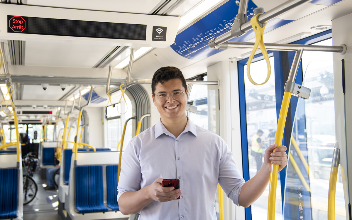 A man holds a phone while riding the ION.