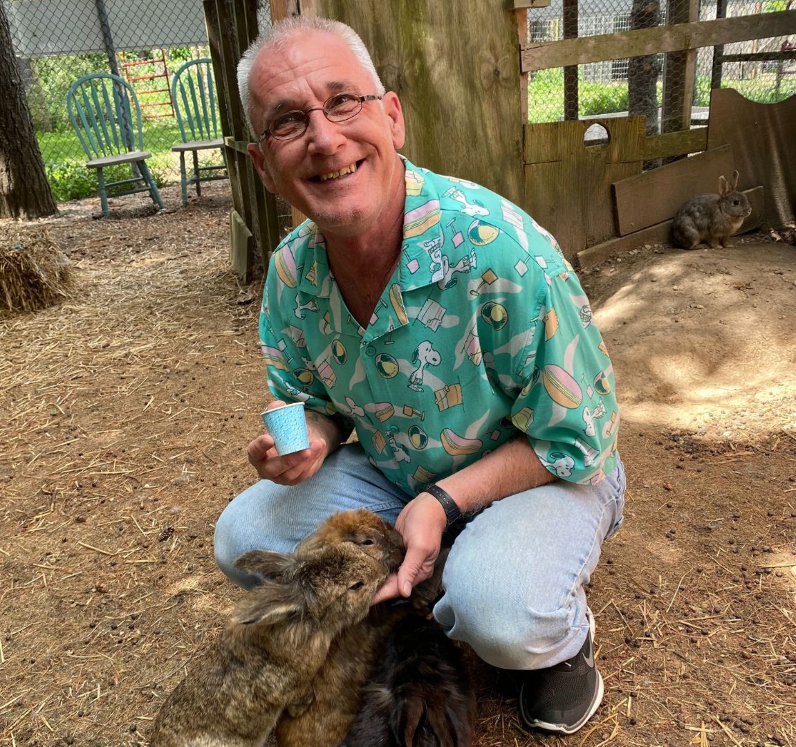 A participant of YODA feeds rabbits at a petting zoo