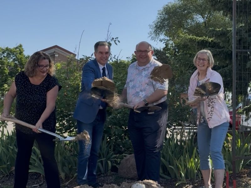 Photo of four people throwing the dirt they shoveled into a pile at the Mill Courtland Expansion groundbreaking