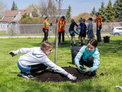 Two young students planting a tree