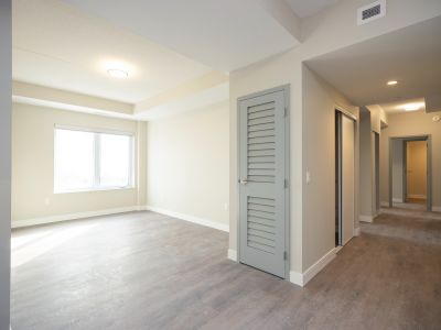 image of a living room area and hallway with doors to bedrooms
