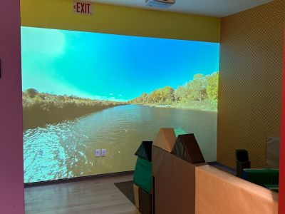 A large screen is on display in a small theatre