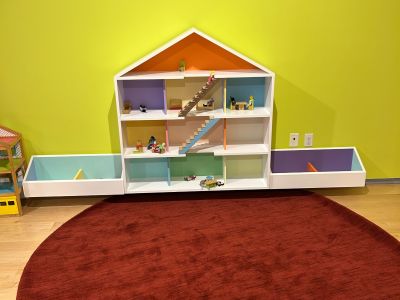 A small playhouse sits on a carpeted area