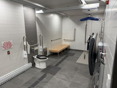 Accessible universal washroom with ceiling lift, adult change table and shower